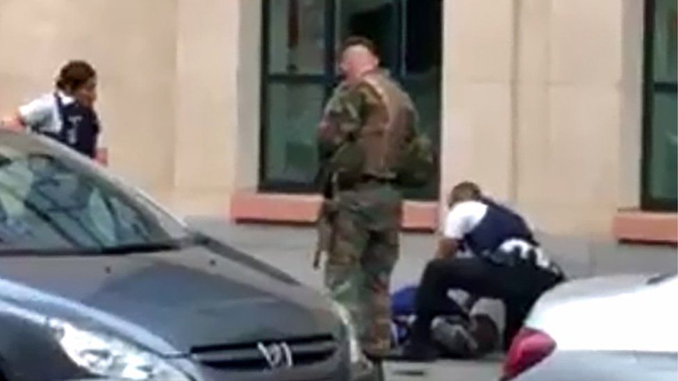 Police tend to an individual following an attack on soldiers in the centre of Brussels, 25 August 2017