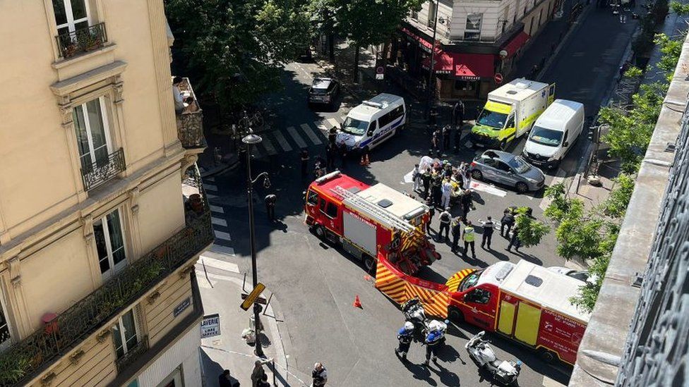 Emergency services treat two occupants of a vehicle who were shot while speeding towards police officers who opened fire, in the 18th district in north Paris, on June 4, 2022