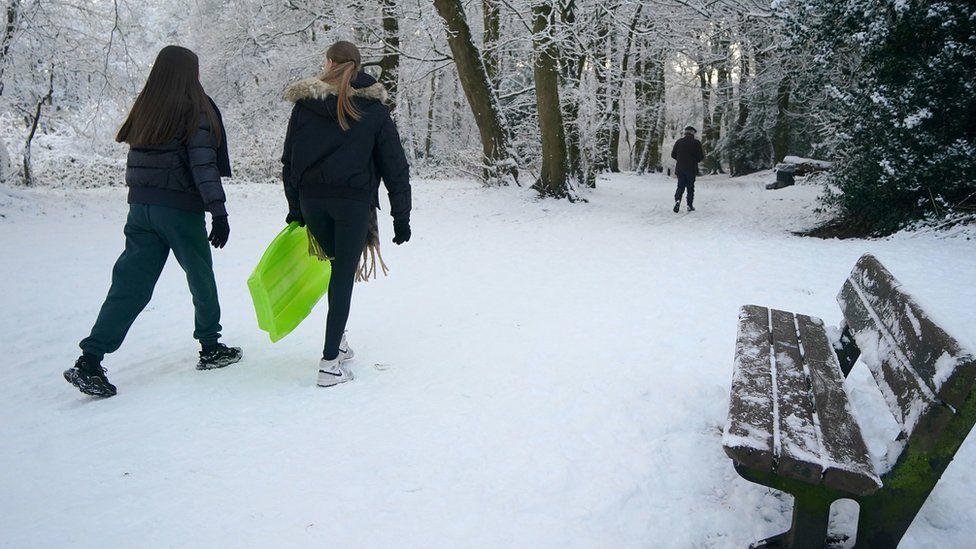 People with sledges make their way to Camp Hill in Woolton, Liverpool.