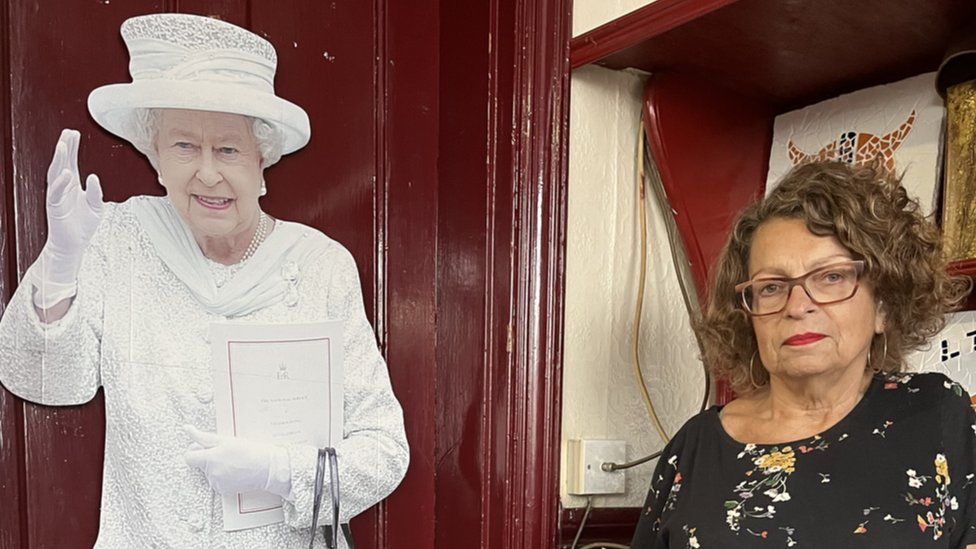 A cardboard cut out of the Queen next to landlady Alison Taylor