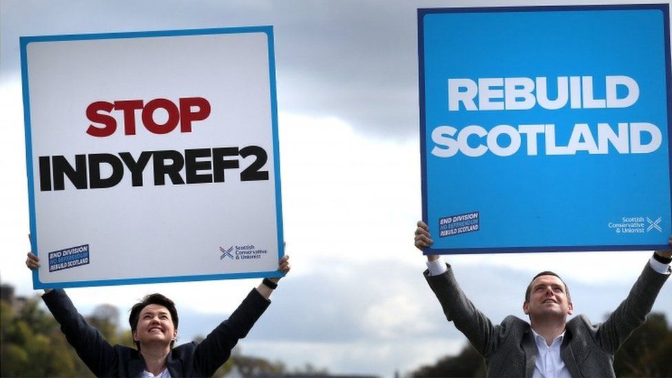 Ruth Davidson and Douglas Ross hold up placards in Stirling