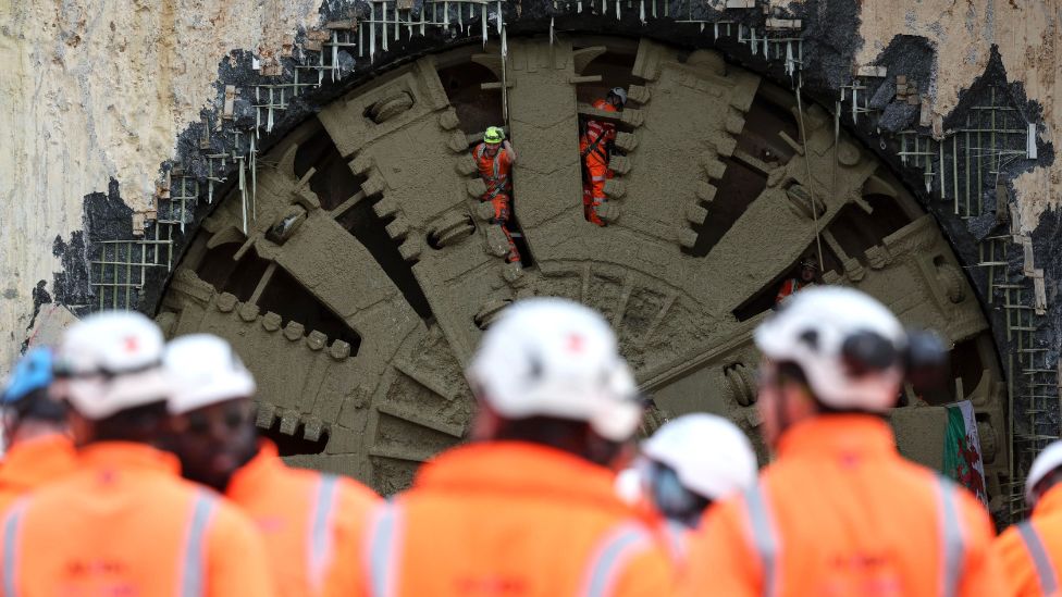 HS2 workers gather to watch the cutter head of the tunnel-boring machine Cecilia breaking through