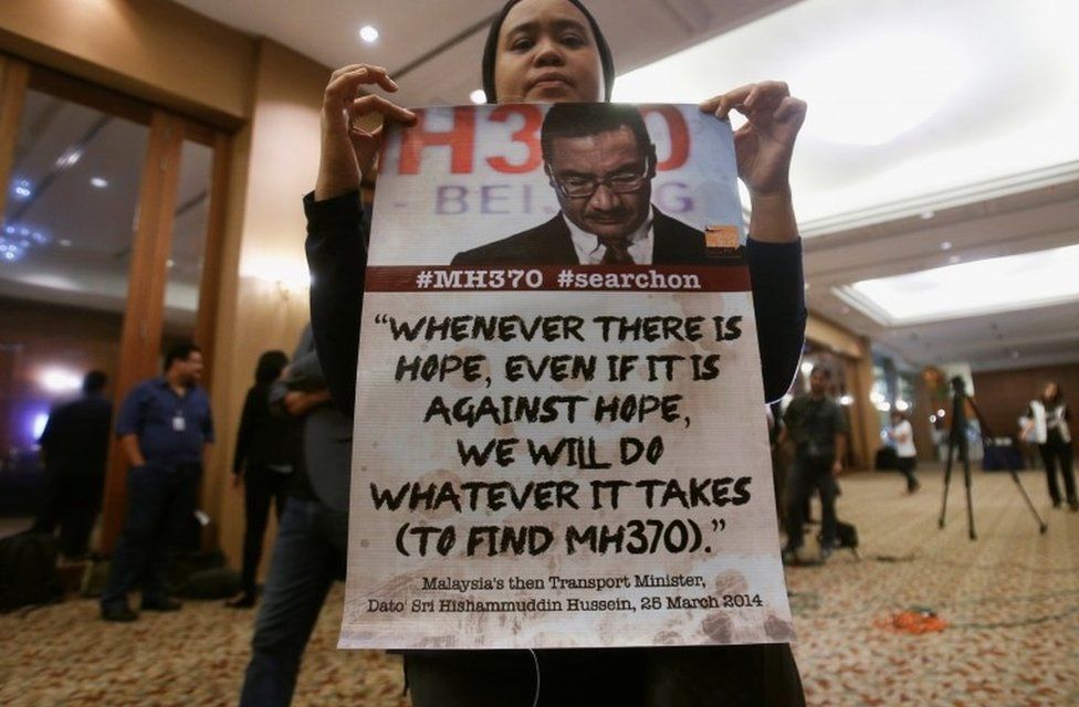 A family member of a passenger onboard the missing Malaysia Airlines flight MH370, shows a poster before the start of a news conference following a meeting with Joint Agency Coordination Centre (JACC) in Kuala Lumpur, Malaysia July 21, 2016.