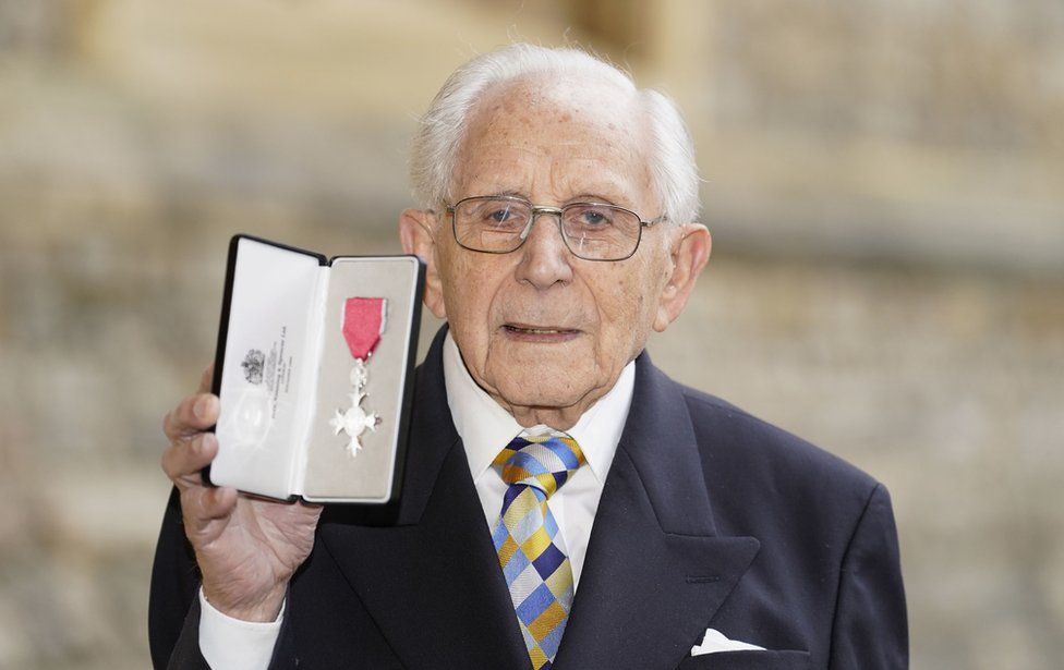 Harry Olmer holding up his MBE