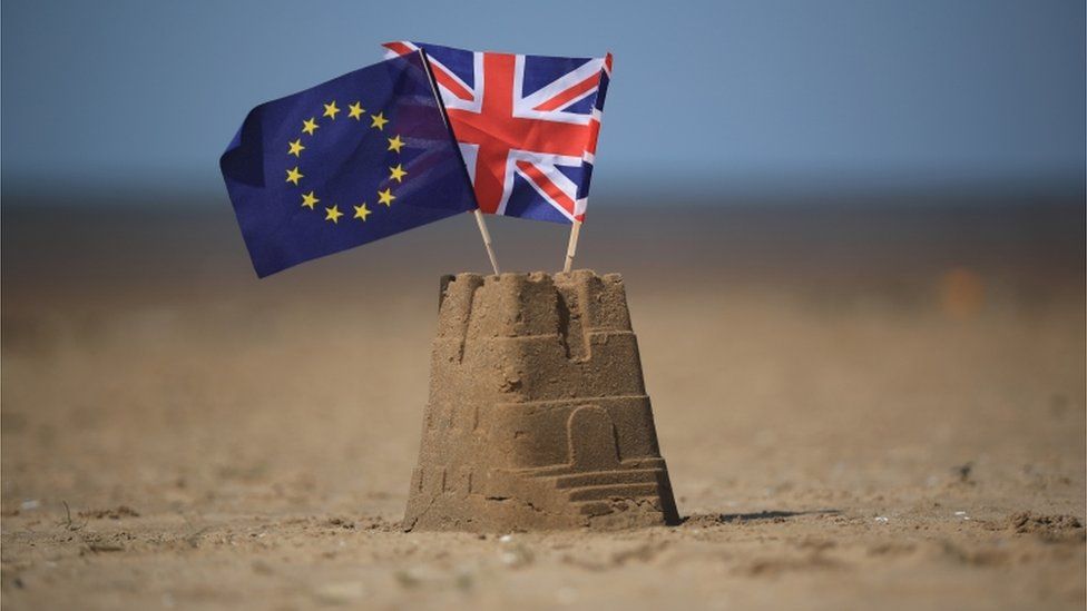 Sandcastle with EU and UK flags