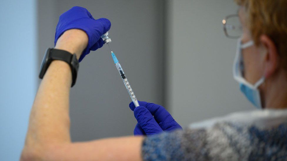 A person draws a dose of vaccine at Sir Ludwig Guttmann Health & Wellbeing Centre in London