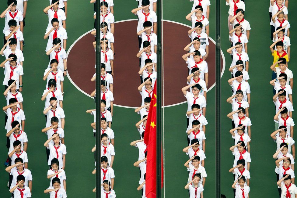 This aerial photo shows children lining up for a flag-raising ceremony.