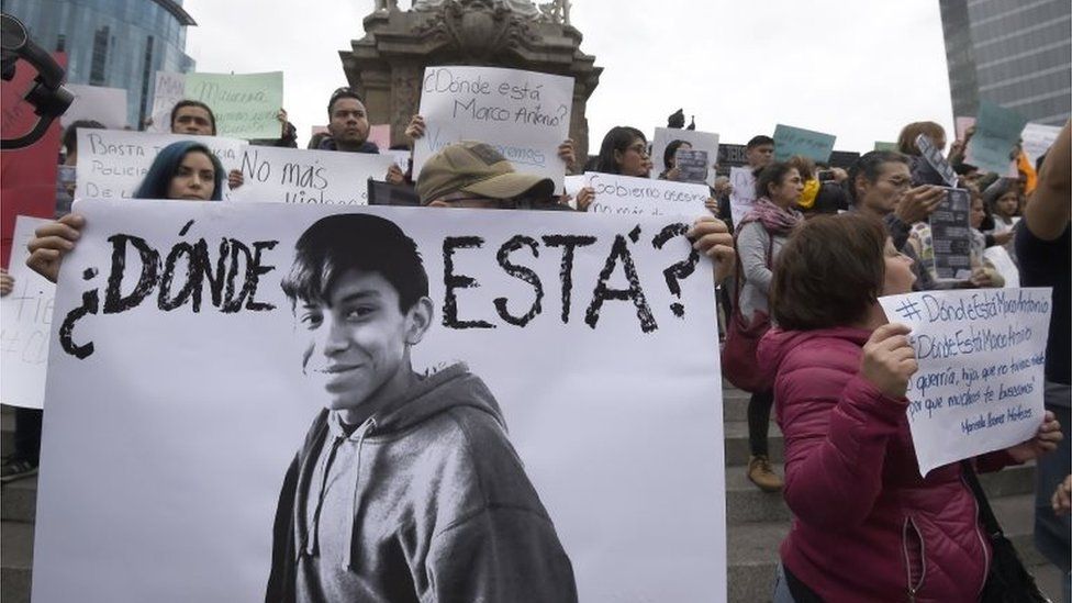 Relatives and students hold posters reading "Where is he?" as they protest against the disappearance of student Marco Antonio Sanchez, at the Angel de la Independencia monument in Mexico City on January 28, 2018