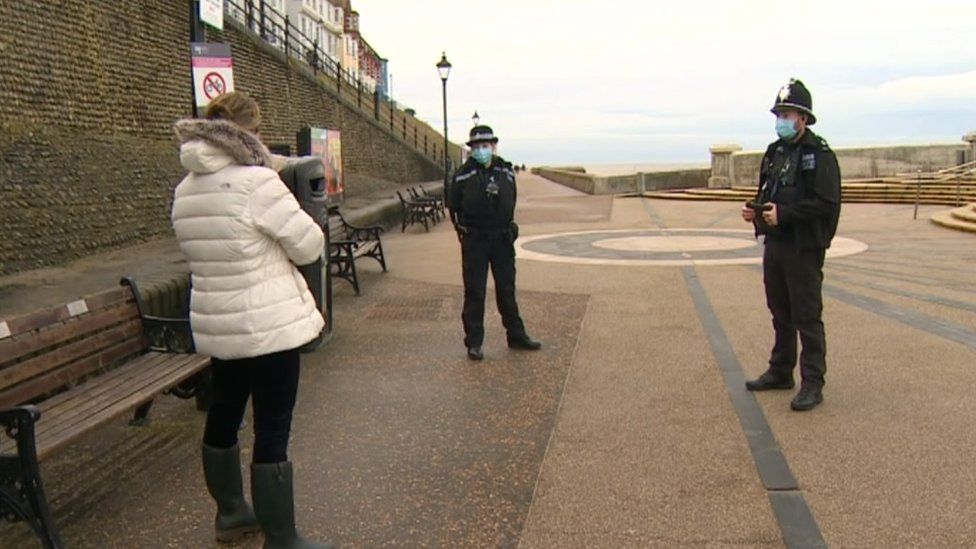 Two police officers stop a member of the public in Cromer, Norfolk.