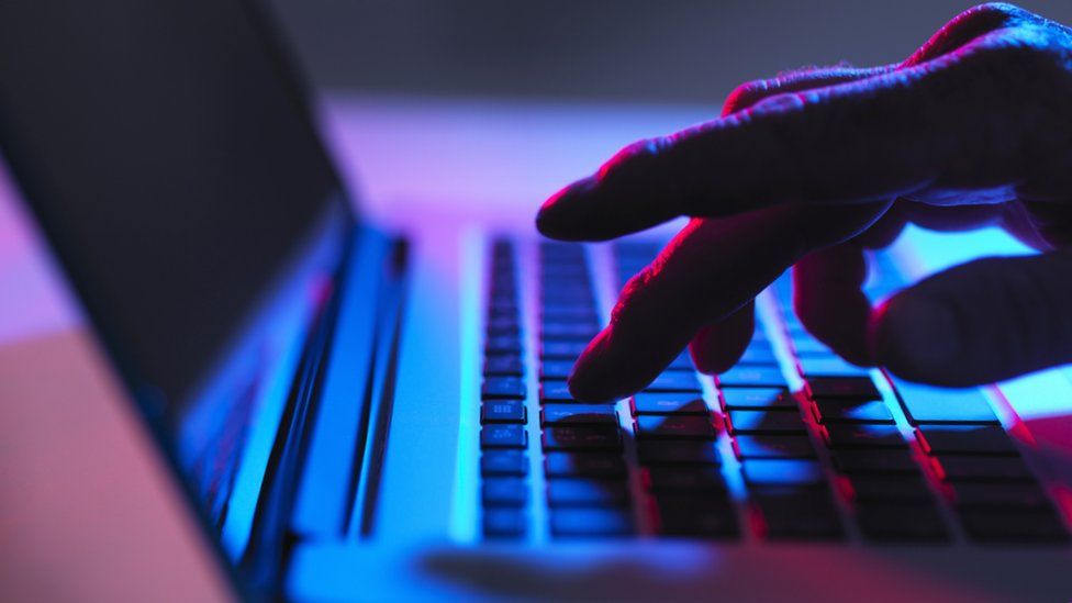 A man's hand using a laptop keyboard