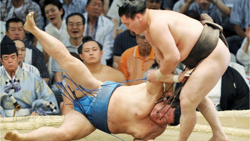 Two sumo wrestlers fight in the 2011 Nagoya Grand Sumo Tournament in Nagoya city in Aichi prefecture