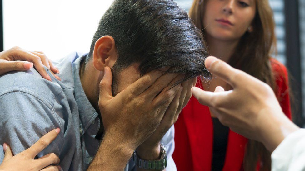 Worried man holds his head in hands