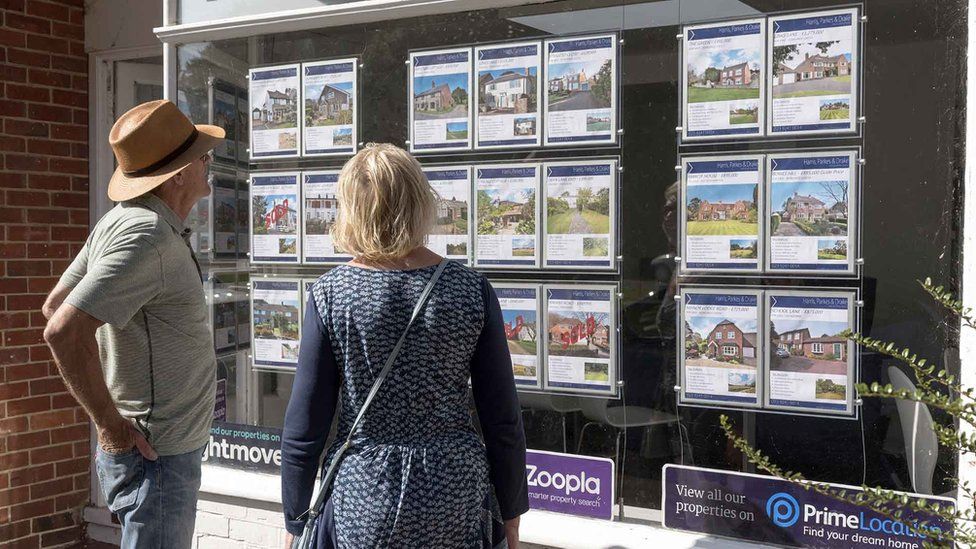 Couple looking in an estate agents' window