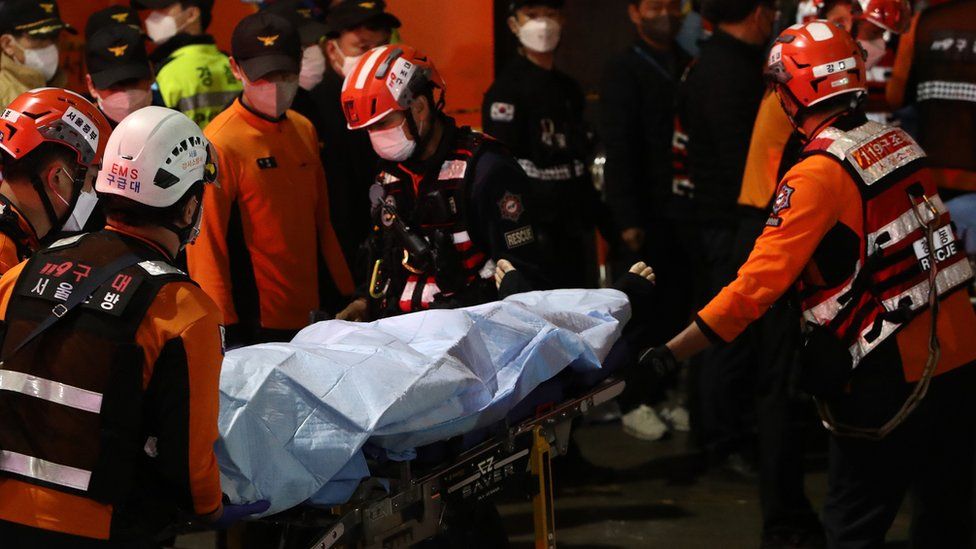 Emergency services transport a person after a stampede during a Halloween celebration October 30, 2022 in Seoul, South Korea.