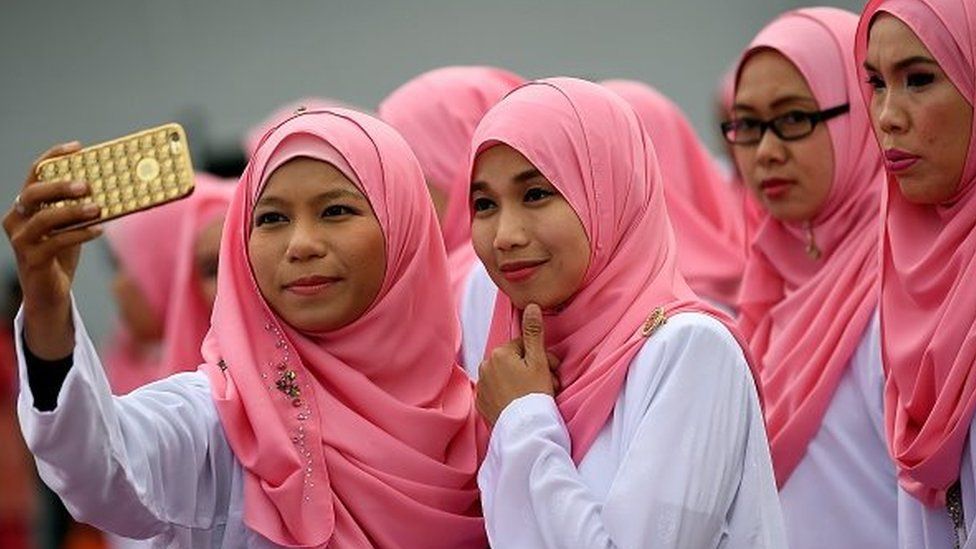 Members of the ruling party United Malays National Organisation (UMNO) pose for photographs before the opening ceremony of the party's annual congress in Kuala Lumpur on December 1, 2016.