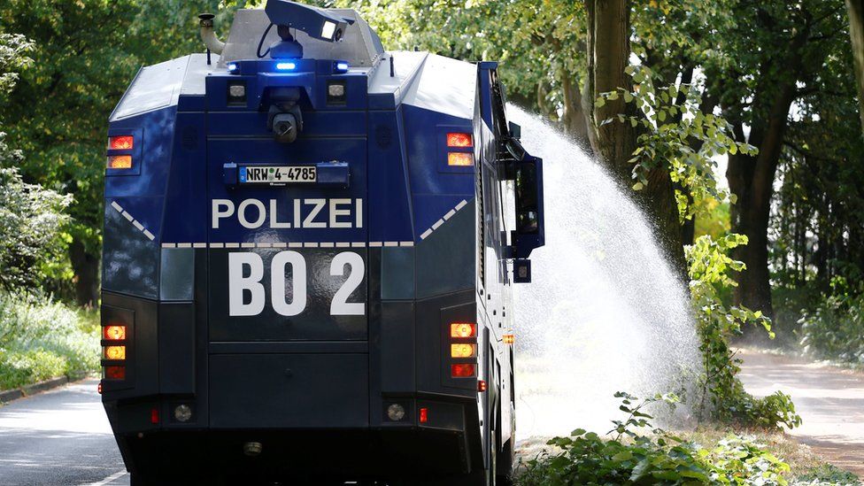 A police water cannon is used to hose trees in Bochum, Germany, 31 July 2018