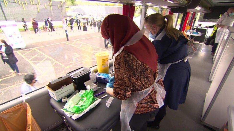 Women on bus prepare Covid vaccinations