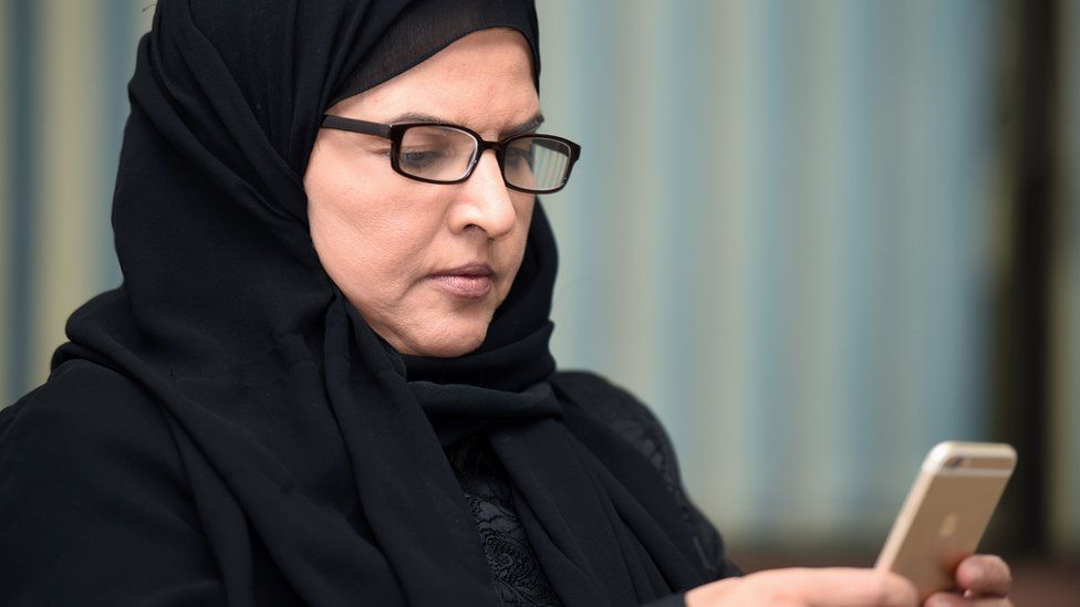File photo showing Saudi activist Aziza al-Yousef checking her mobile phone in Riyadh on 27 September 2016