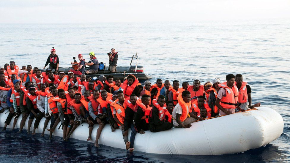 Migrants are seen in a rubber dinghy in the Mediterranean as they are rescued by the crew of Mission Lifeline, 21 June 2018.