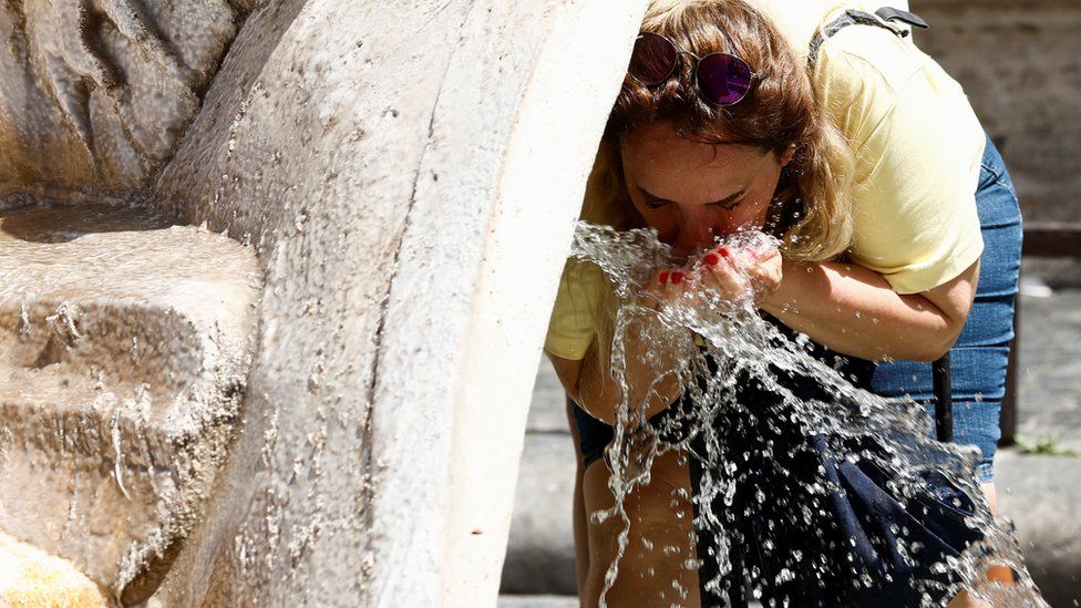 A person cools off at the Fontana della Barcaccia, at the Piazza di Spagna