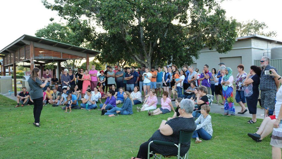 Around 80 people gather at a local park for a vigil