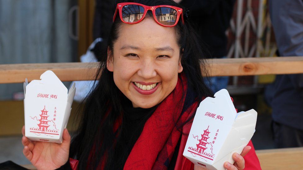 Yiying Lu holding two takeout boxes