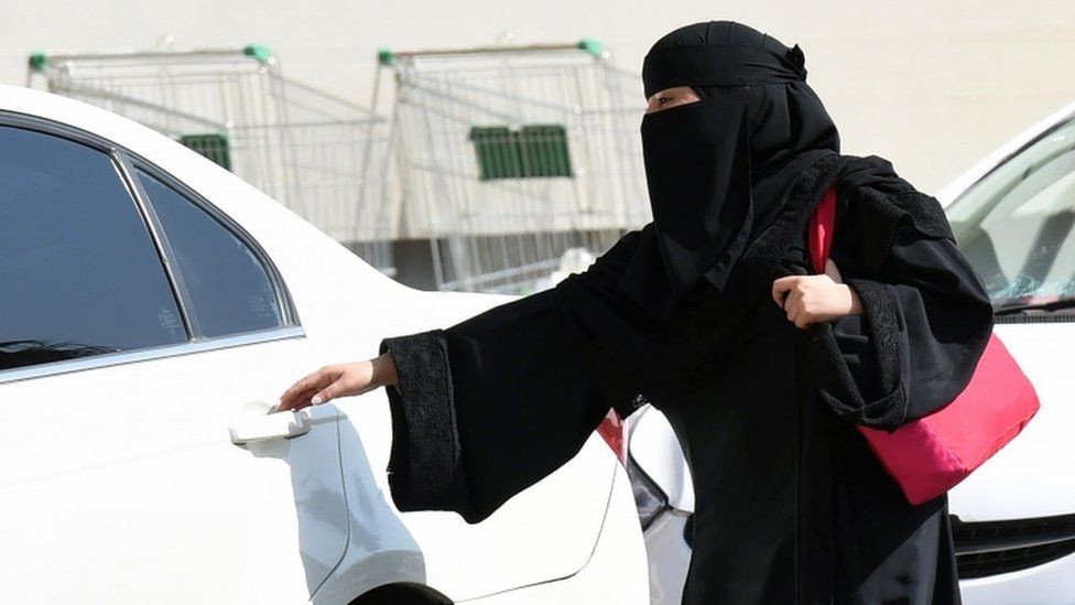 A Saudi woman wearing a Niqab gets into a taxi at a mall in Riyadh as a grassroots campaign planned to call for an end to the driving ban for women in Saudi Arabia on October 26, 2014.