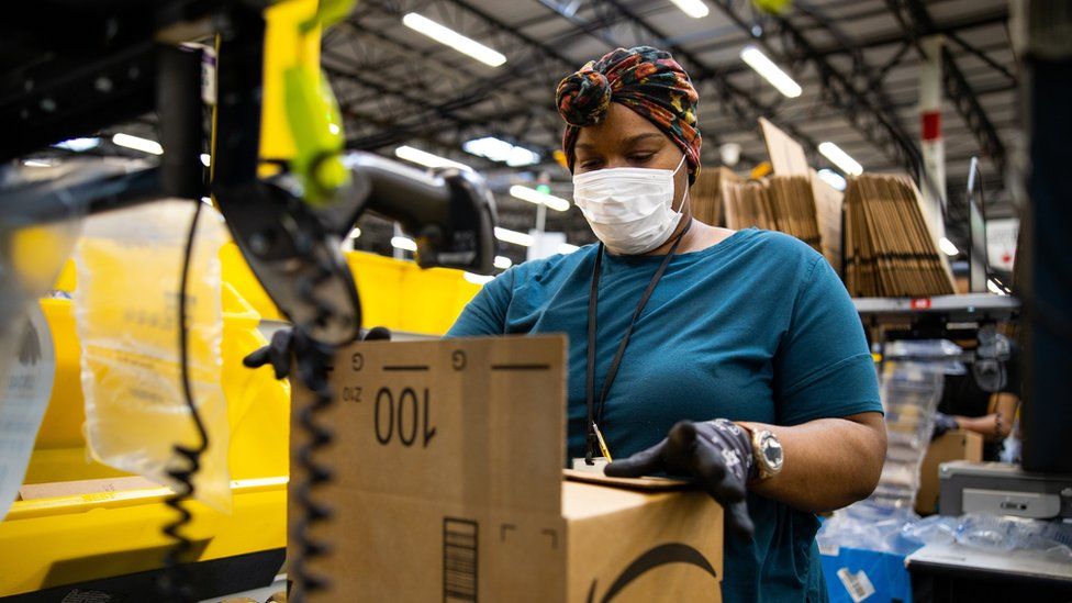 Amazon employee packing a box