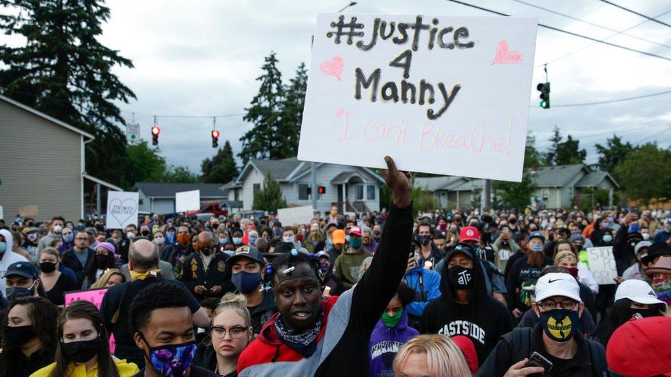Family, friends and community members attend a vigil at the intersection where Manuel Ellis, a 33-year-old black man, died in Tacoma Police custody on March 3 and was recently ruled a homicide, according to the Pierce County Medical Examiners Office, in Tacoma, Washington