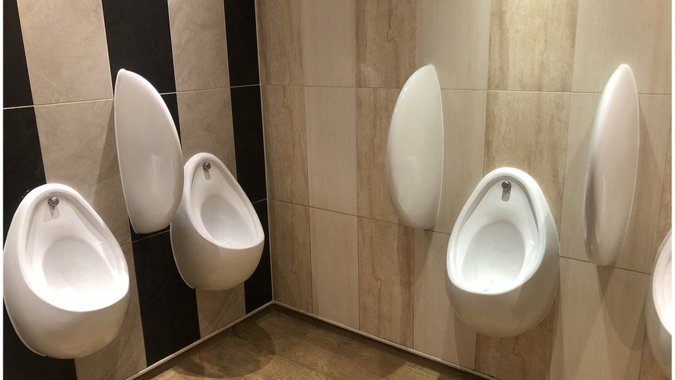 Three white urinals