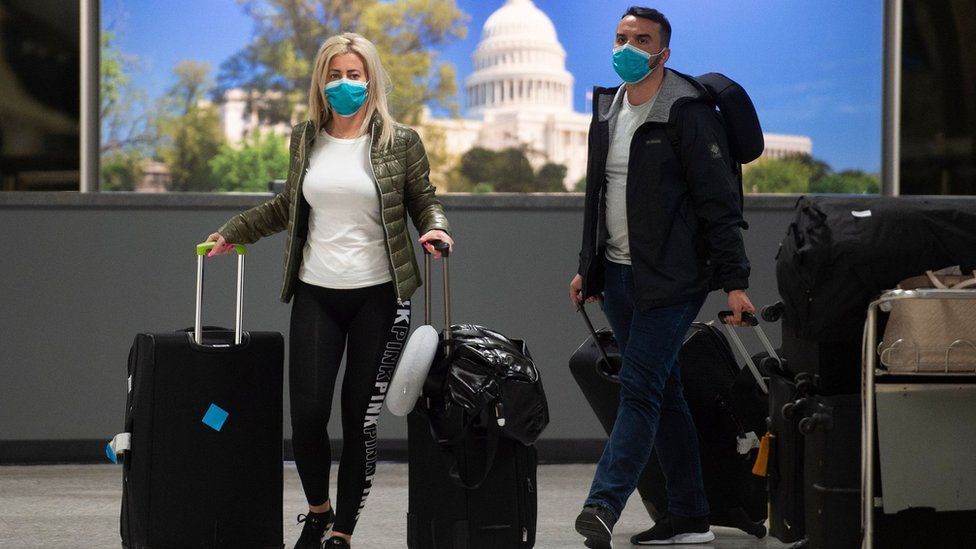 Passengers arrive at Dulles International Airport in Virginia on 17 March 2020