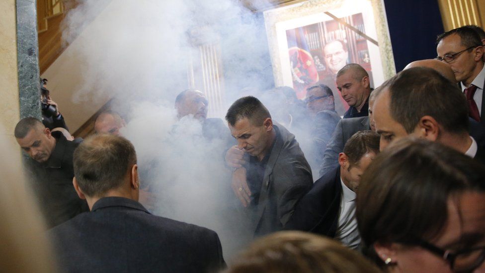Opposition MPs throw tear gas as Kosovo police officers stop them from attending a continuing session of the parliament in Pristina