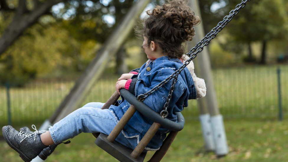 Young girl on swing in play park (stock image)
