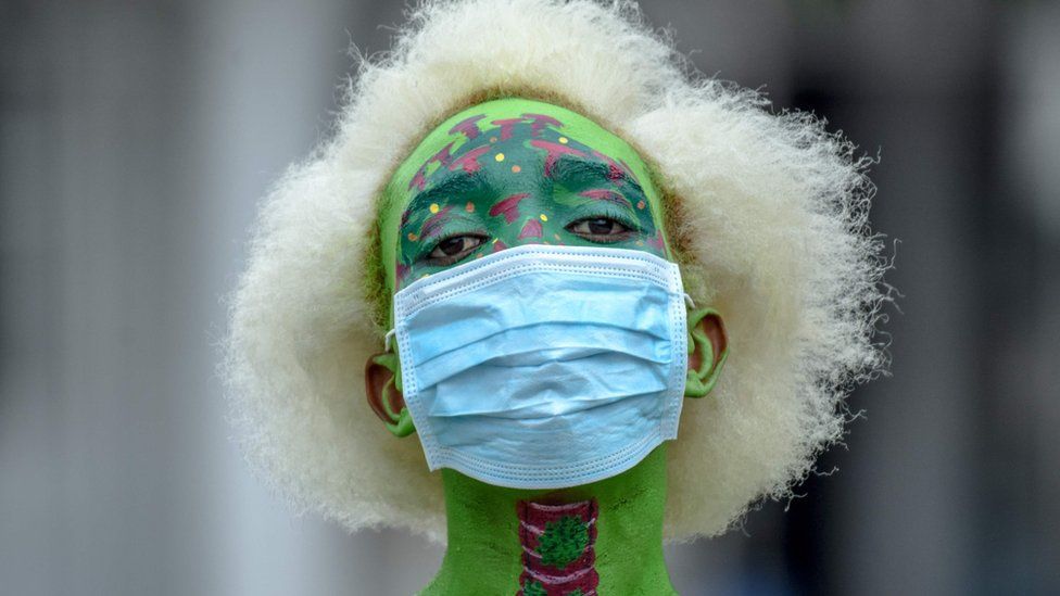 A Tanzanian performance artist t Alex Kalemera dressed up in a mask