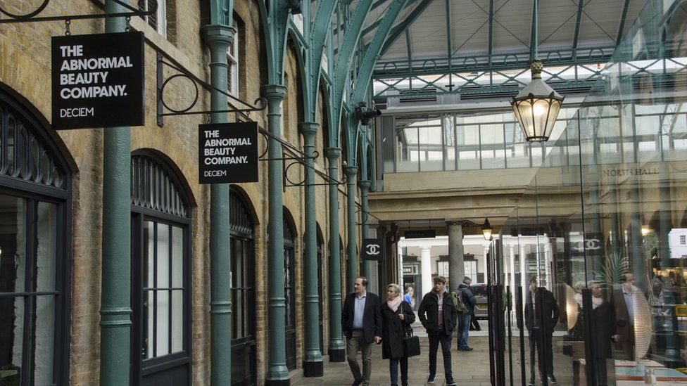 Passers in front of the 'Deciem' abnormal beauty company at the north hall of the New Covent Garden Market