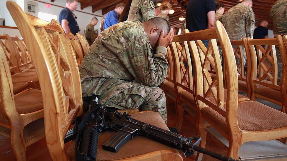 Американский солдат держит голову во время молитвы 11 сентября 2011 года на аэродроме Баграм