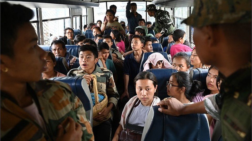 Meitei refugees wait onboard a paramilitary truck at a transit point after being evacuated from the violence that hit Churachandpur, near Imphal in the north-eastern Indian state of Manipur on May 9, 2023.