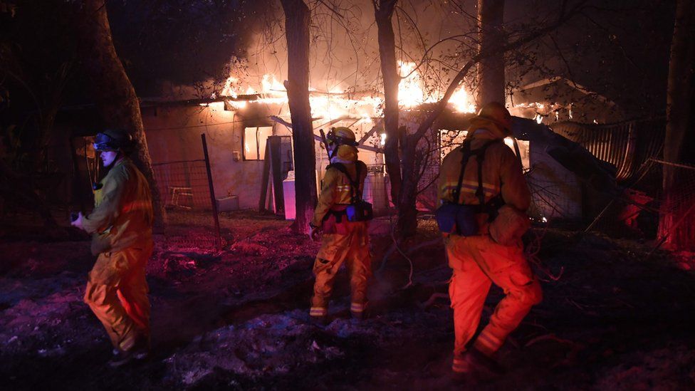 Пожарные исследуют горящий дом, поскольку лесной пожар Томаса продолжает гореть в Карпинтерии, Калифорния, 10 декабря 2017 г.