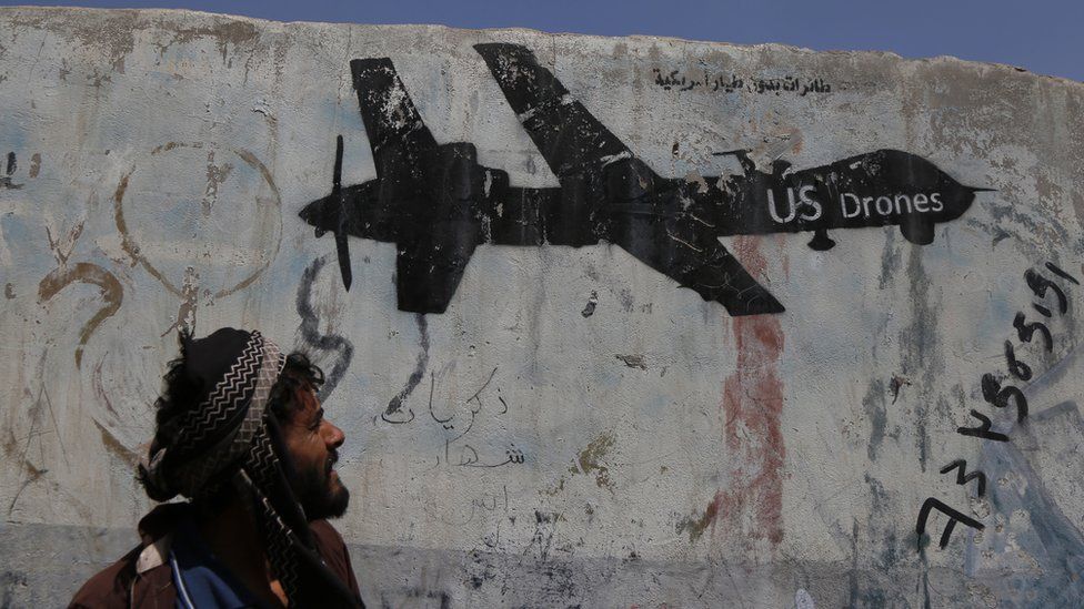 A Yemeni man looks at graffiti protesting against US drone strikes