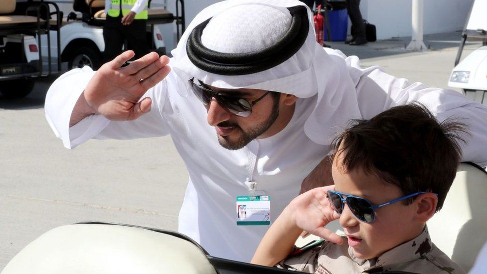 Crown Prince of Dubai, Sheikh Hamdan bin Mohammed bin Rashid al-Maktoum, poses for a picture with a child during the Dubai Airshow on November 14, 2017, in the United Arab Emirates