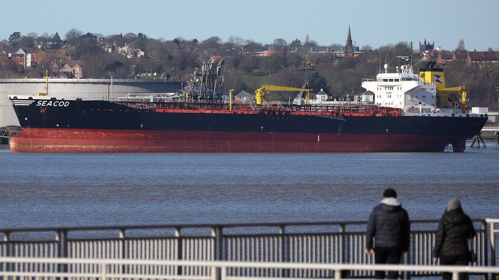 People walk past the vessel berthed on the Mersey