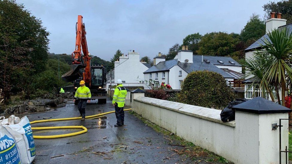 Workers pumping water out of homes in Laxey