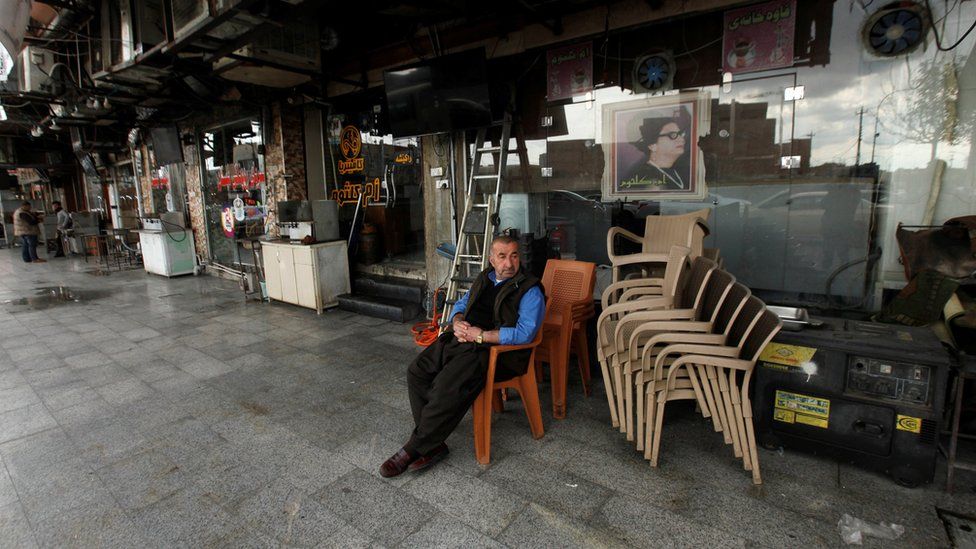A Kurdish man sits near a closed cafe in Irbil (2 March 2020)