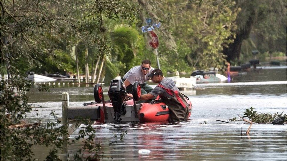 Bonita Springs Fire Department officials assess the damage in a flooded neighbourhood in Bonita, Springs, Florida.