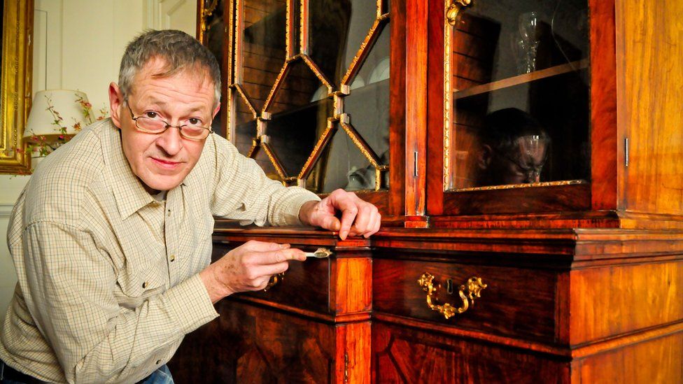Conservation expert James Hardie working on the bookcase