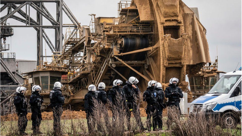 Police officers stand in front of a bucket-wheel excavator on January 2, 2023 in Luetzerath, Germany.
