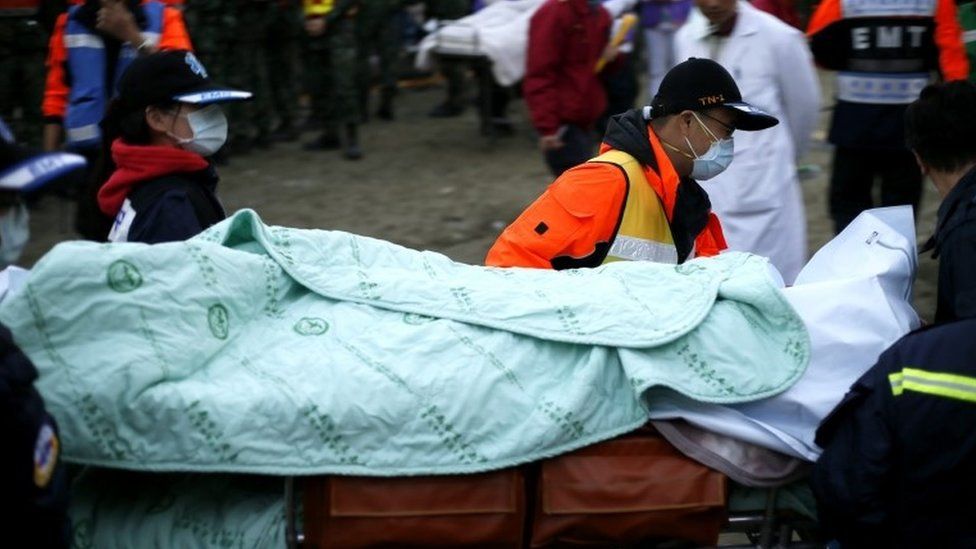 Rescuers transport a body on the second day of search and rescue operation from a collapsed building following a 6.4 magnitude earthquake struck on 06 February in Tainan City, southern Taiwan, 07 February 2016