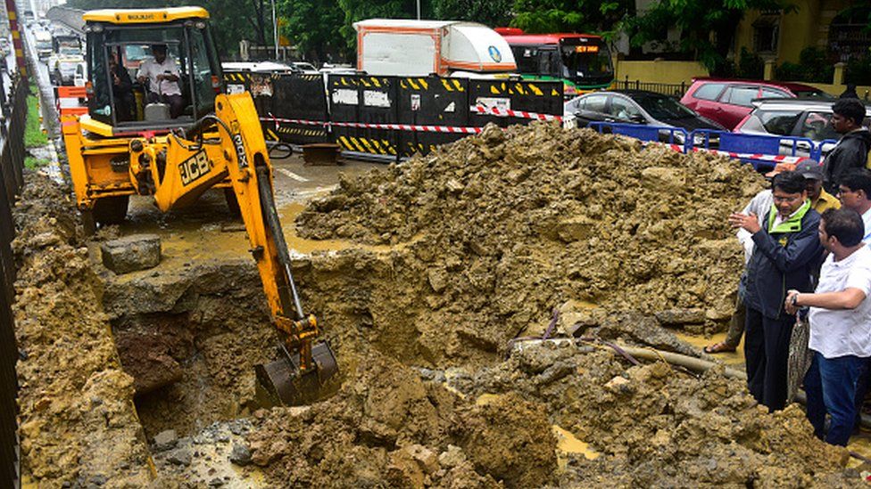 Рабочий BMC ремонтирует протекающий водопровод на Дадар ТТ 5 июля 2022 г. в Мумбаи, Индия. Мумбаи переживает проливной дождь в разгар сезона дождей.