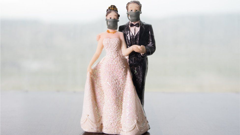 Plastic wedding couple wearing face masks