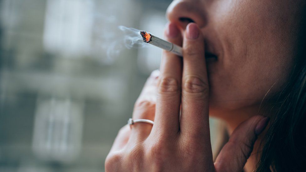 Фотография курящей женщины крупным планом